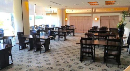 a dining room with tables and chairs in a restaurant at Hotel Harvest Nankitanabe in Tanabe