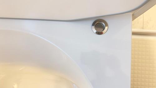 a bathroom with a white toilet with a silver handle at The SAKAI newly built home 7 mins walk from Train Station in Abiko