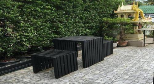 two black benches sitting on a brick patio at SP. Place Hotel in Ko Chang