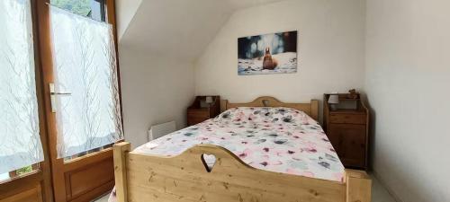 a bedroom with a wooden bed with flowers on it at Joli triplex 3 étoiles, avec jardin et cheminée in Génos