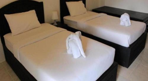 two beds with white towels on them in a room at SP. Place Hotel in Ko Chang
