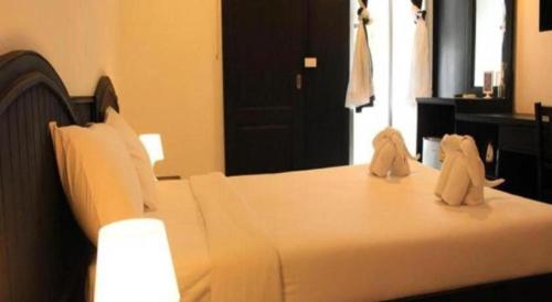 two stuffed animals sitting on top of a bed at SP. Place Hotel in Ko Chang