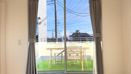 a table and a chair outside a window at The SAKAI newly built home 7 mins walk from Train Station in Abiko