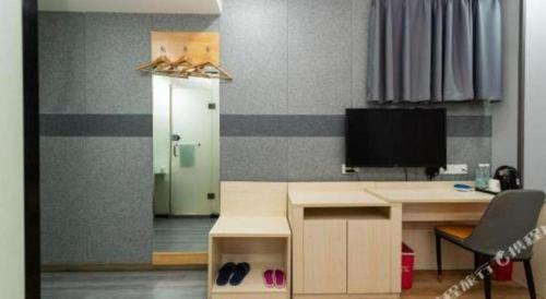 a room with a desk with a computer and a tv at Pai Hotel Xi'an Electronic Zheng Street in Xi'an