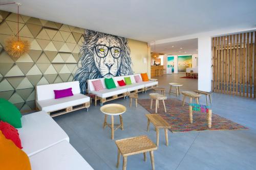 a lobby with a mural of a lion with glasses at Hotel Vibra Bossa Flow - Adults only in Playa d'en Bossa