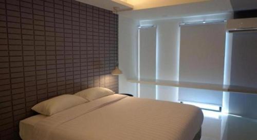 a bedroom with a white bed and a window at Silom Studios in Bangkok