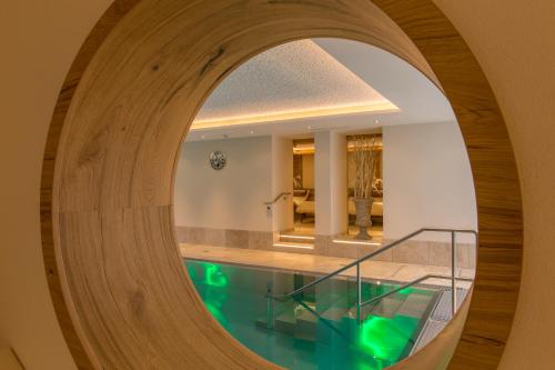 un pasillo circular con piscina en una casa con espejo en Alpenland Gerlos - Hotel & Breakfast, en Gerlos