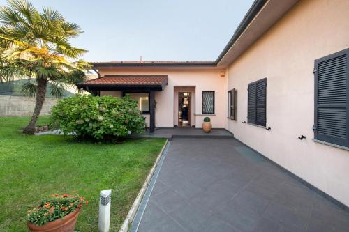 a driveway leading to a house with a palm tree at Dreams To Lake Como in Senna Comasco