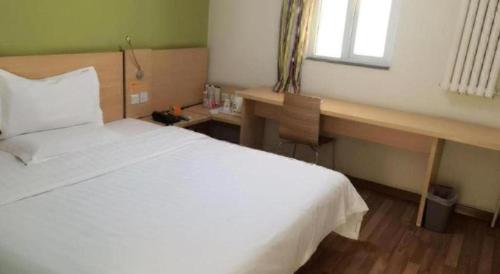 a bedroom with a white bed and a desk at 7 Days Inn West Gate of Taiyuan University of Technology in Taiyuan