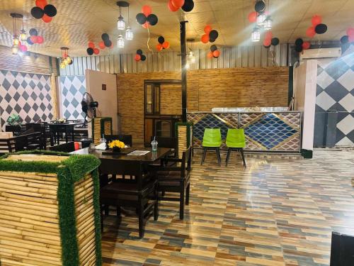 Un comedor con mesas y sillas verdes. en Hotel Urban Nest, en Noida
