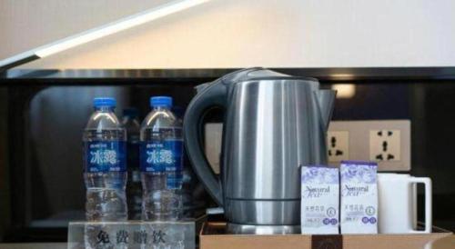 a coffee pot and bottles of water on a counter at Lavande Hotel Xi'an Longshouyuan Wenjing Road in Xi'an