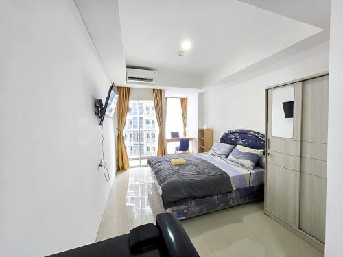a bedroom with a bed and a tv in a room at Strategic Pacific Gardenia studio Alam Sutra pool and Gym by Luckystay in Warungnangka
