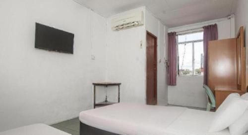 a white room with a bed and a television at OYO 89706 To-day Hotel in Sibu