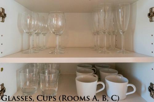 a shelf with wine glasses and cups on it at Ginkgo House ギンコハウス in Fujiyoshida