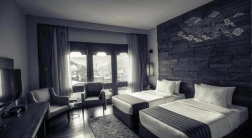 a hotel room with two beds and a couch at The Pema by Realm in Thimphu