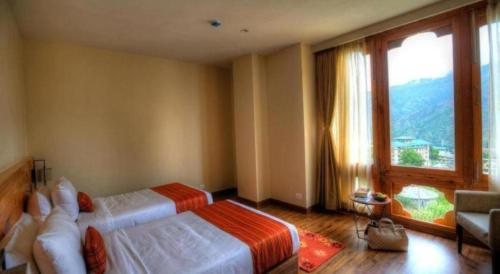 a hotel room with two beds and a large window at The Pema by Realm in Thimphu