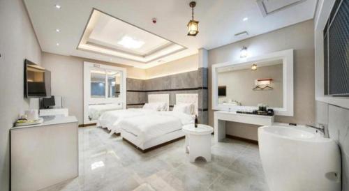 a bedroom with a bed and a bathroom with a sink at SH Hotel in Mokpo