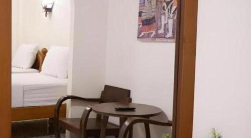 a small room with a table and a bed and a table and chair at Nan Lanna Hotel in Nan