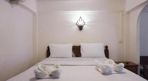 a bedroom with a bed with two towels on it at Nan Lanna Hotel in Nan