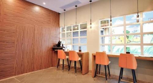 a kitchen with a table with orange chairs and a window at London Hotel in Macau