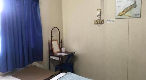 a room with a bed and a desk with a mirror at SPOT ON 90625 Super Green Grass Hotel in Yong Peng