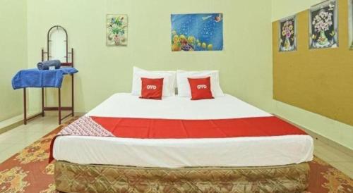 a bedroom with a large bed with red pillows at SPOT ON 90625 Super Green Grass Hotel in Yong Peng