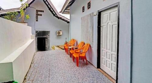 a row of orange chairs sitting on the side of a building at OYO 91886 Bfs Homestay Syariah in Jambi