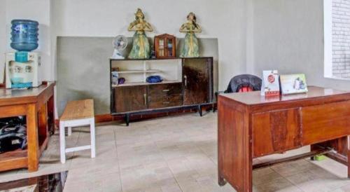 a living room with wooden furniture and a table at OYO 91920 Pondok'ku Inn in Yogyakarta