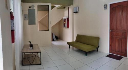 a hallway with a green chair and a table at OYO 800 DDD Habitat Dormtel Bacolod in Bacolod