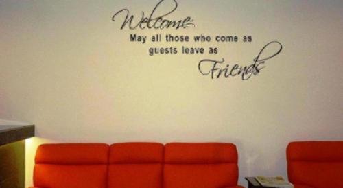 a living room with a wall with a welcome may all those who come as guests at G Six Hotel in Sitiawan
