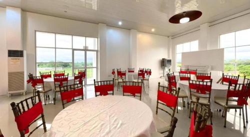 a conference room with a table and red chairs at Pilot Hotel in Alaminos