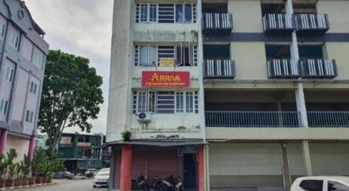 a tall building with a red sign on it at Hotel O Arriva Travellers in Kuching