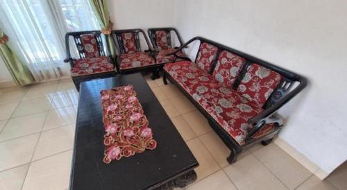 a row of chairs with red cushions on a table at Hotel O Wisma Sidosari Syariah in Bandar Lampung