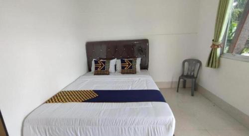 a bedroom with a large bed in a room at Hotel O Wisma Sidosari Syariah in Bandar Lampung