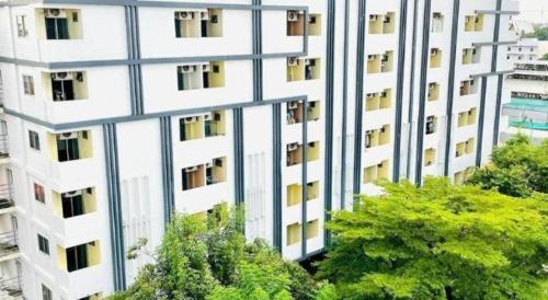 an external view of a tall white building at ONE Residence in Pathum Thani