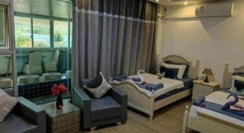 a bedroom with two beds and a chair and a couch at Crystal Palace Hotel in Port Vila