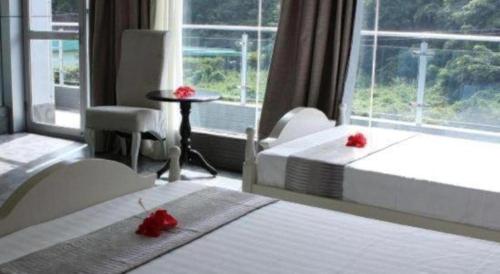 a hotel room with two beds and a window at Crystal Palace Hotel in Port Vila