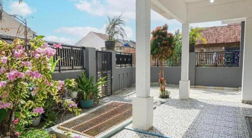 a porch with a fence and some flowers at Hotel O Wisma Sidosari Syariah in Bandar Lampung