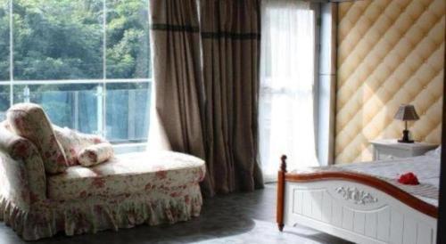 a bedroom with a bed and a chair and a window at Crystal Palace Hotel in Port Vila