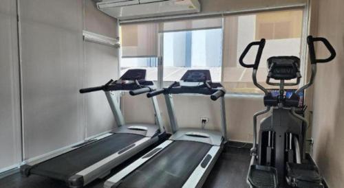 a gym with two tread machines in a room at ONE Residence in Pathum Thani