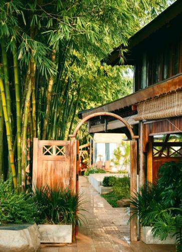 an entrance to a house with a wooden gate and trees at Jun's Home in Buon Ma Thuot