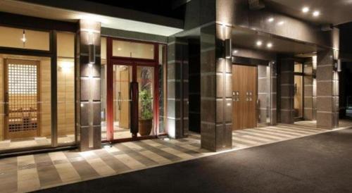 a row of doors on a building at night at Hotel Sunoak Kashiwanoha in Kashiwa