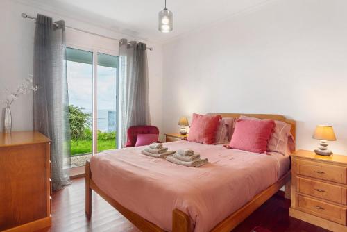 a bedroom with a bed with pink pillows and a window at Blissful Haven - Soulful Stays in Ilhéu Mole