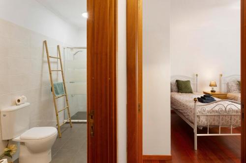 a bathroom with a toilet and a bed in a room at Blissful Haven - Soulful Stays in Ilhéu Mole