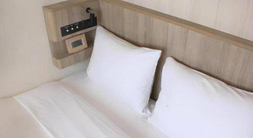 two white pillows on a bed in a room at Hotel IL FIORE Kasai in Tokyo