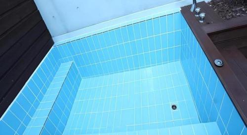 a blue tiled bath tub in a bathroom at Crossing Hotel in Seoul