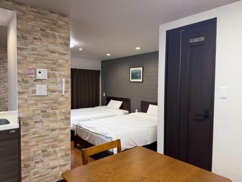 a room with two beds and a table and a kitchen at SA in Nagano Ishido - Vacation STAY 07380v in Nagano