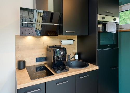 a kitchen with a sink and a coffee maker on a counter at Luxuscontainer am Nürburgring #3 in Adenau