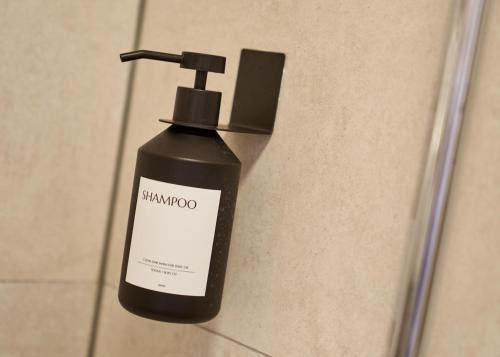 a black bottle of shampoo sitting on a wall at Luxuscontainer am Nürburgring #3 in Adenau