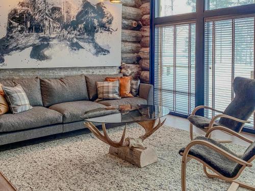 a living room with a couch and a table and chairs at Holiday Villa Karhunkelo - sis 4 kpl hissilippuja in Ukkohalla